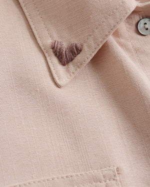 Close-up of a beige fabric with a button and stitching detail