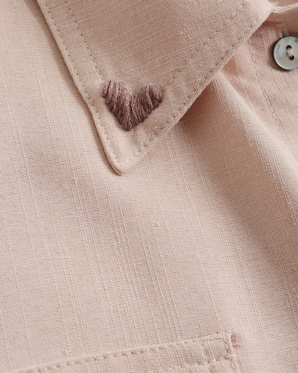 Close-up of a beige fabric with a button and stitching detail