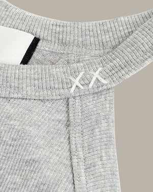 Close-up of a gray ribbed tank with brand logo on a beige background