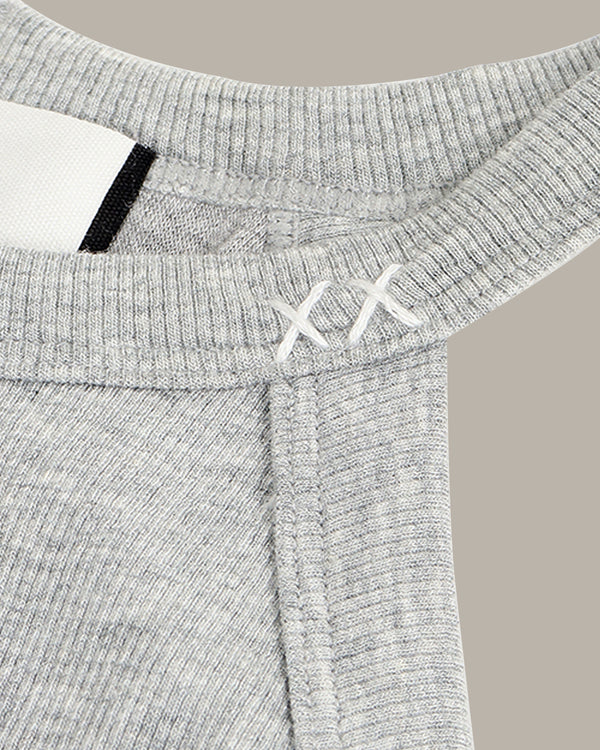Close-up of a gray ribbed tank with brand logo on a beige background
