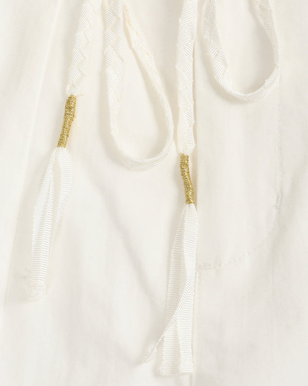 Close-up of a white garment with gold accents