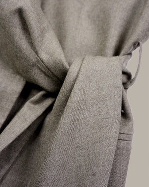 Close-up of a light gray textured fabric tie belt knotted at the waist, showing the woven material detail against a neutral background.