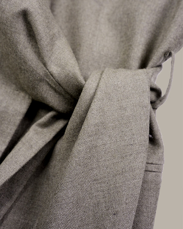 Close-up of a light gray textured fabric tie belt knotted at the waist, showing the woven material detail against a neutral background.