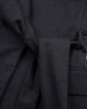 Close-up of a dark charcoal gray textured fabric, showing a tie detail and pocket stitching.