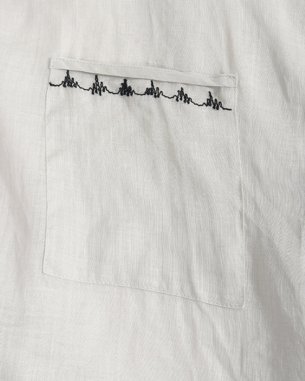 Close-up of a white textured fabric pocket with a black embroidered heartbeat line across the top edge.