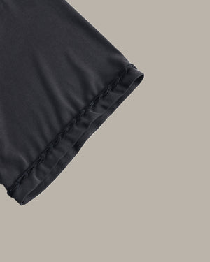Close-up of black satin fabric on a beige background