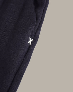 Navy blue pants with a white logo on a beige background