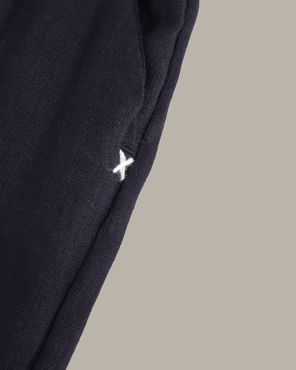 Navy blue pants with a white logo on a beige background