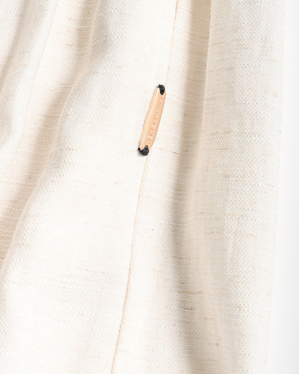 Close-up of a textured off-white pants with a small beige leather brand tab sewn onto the seam. The tab features the brand name 'CHLOECHEN' in black text.