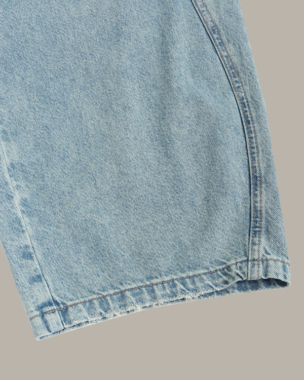 Close-up of light blue denim fabric on a gray background