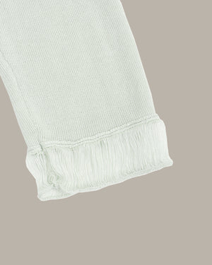 Light green ribbed knit fabric on a beige background