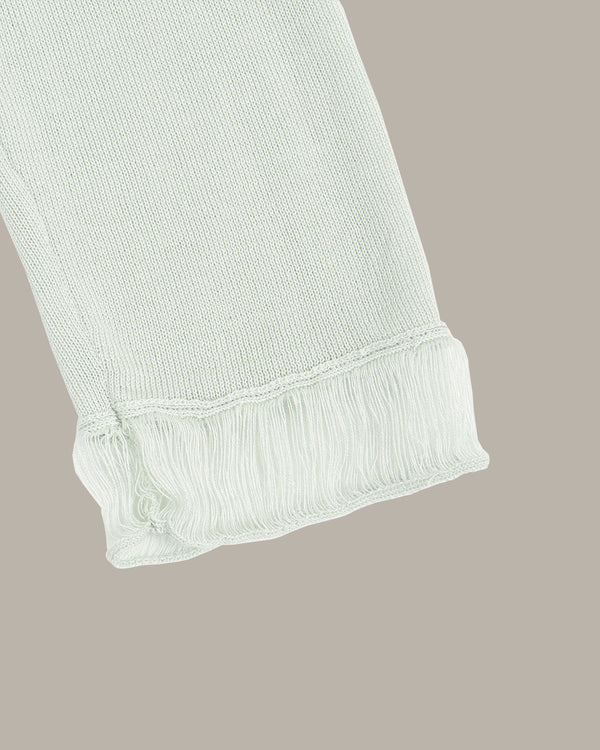 Light green ribbed knit fabric on a beige background