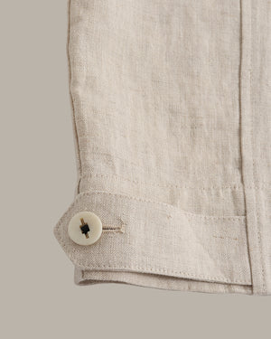 Close-up of a beige jacket with a button on a light gray background