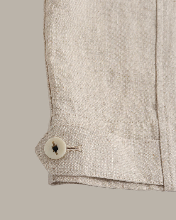 Close-up of a beige jacket with a button on a light gray background