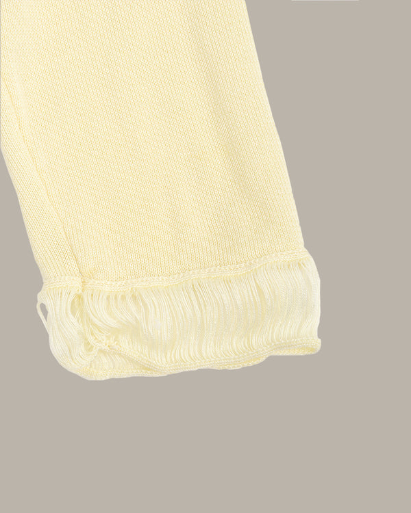 Close-up of a yellow fabric with frayed edges on a gray background