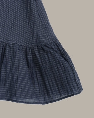 Navy blue ruffle top on a beige background