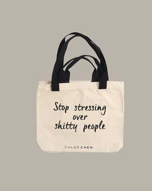 Tote bag with text 'Stop stressing over shitty people' by Chloe Chen on a beige background